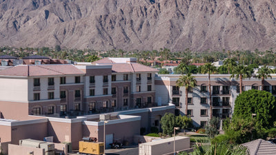 Close view of Embassy Suites La Quinta balconies, palm trees, and the Santa Rosa Mountains.