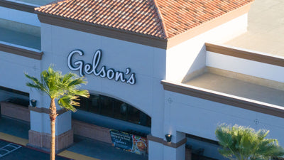 Gelson’s sign above the Rancho Mirage market entrance, framed by palm trees and a red tile roof; photographed by Mark Miller on October 13, 2026