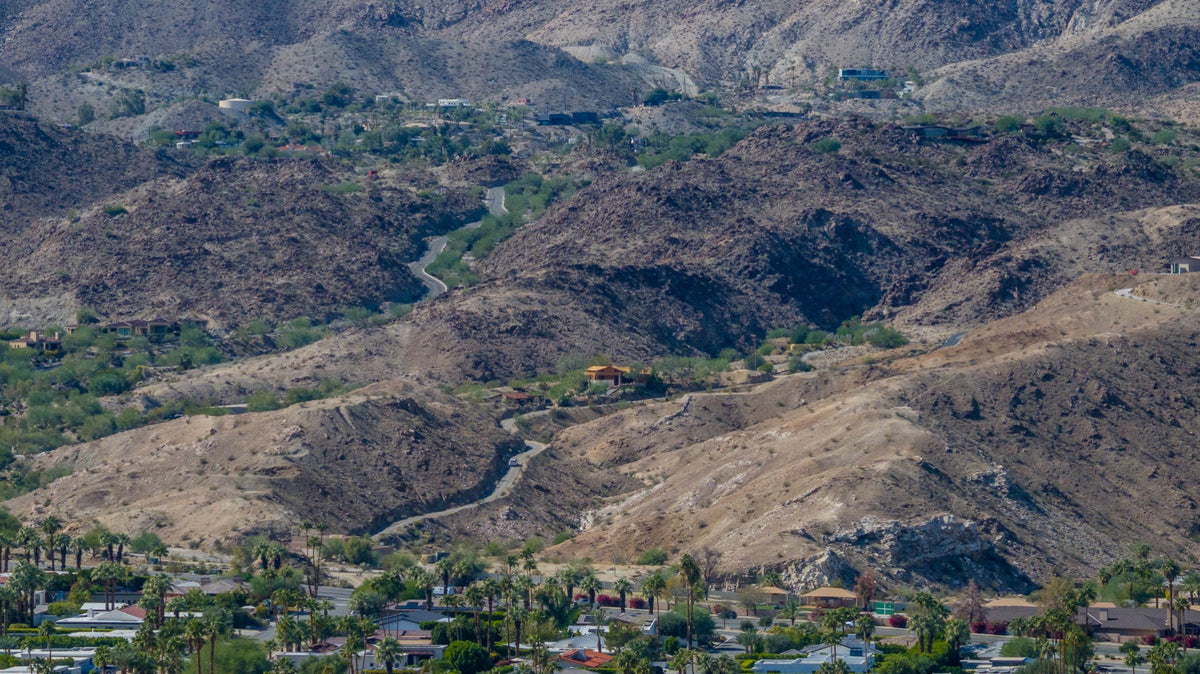 Rocky ridges, a desert wash and homes in the Haystack Mountain area