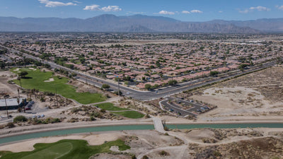 View from the Indio Hills across the canal, trail parking area, golf course and neighborhoods toward distant mountains.