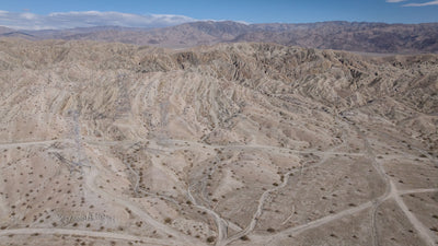 Aerial view of eroded Indio Hills ridges and sandy washes beneath a blue sky, photographed by Mark Miller on September 29, 2026.