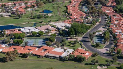 Aerial view of La Quinta Country Club homes, internal streets, pools, tennis courts and golf-course landscaping.