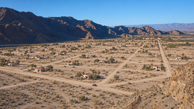 AI-generated interpretation of La Quinta Cove circa 1935–1941, with scattered Spanish-style casitas, dirt roads and La Quinta Resort depicted in the distance.