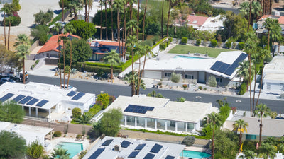 Aerial detail of single-story desert homes and mature palms in Magnesia Falls Cove