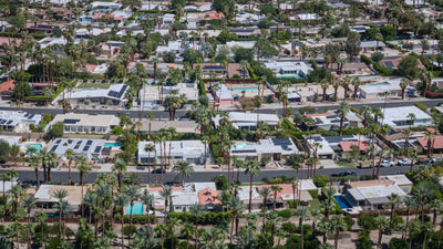 Aerial view of single-story homes, palms, and backyard pools in Magnesia Falls Cove