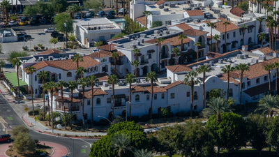 Spanish-style storefronts and red tile rooftops beside a roundabout in Old Town La Quinta.