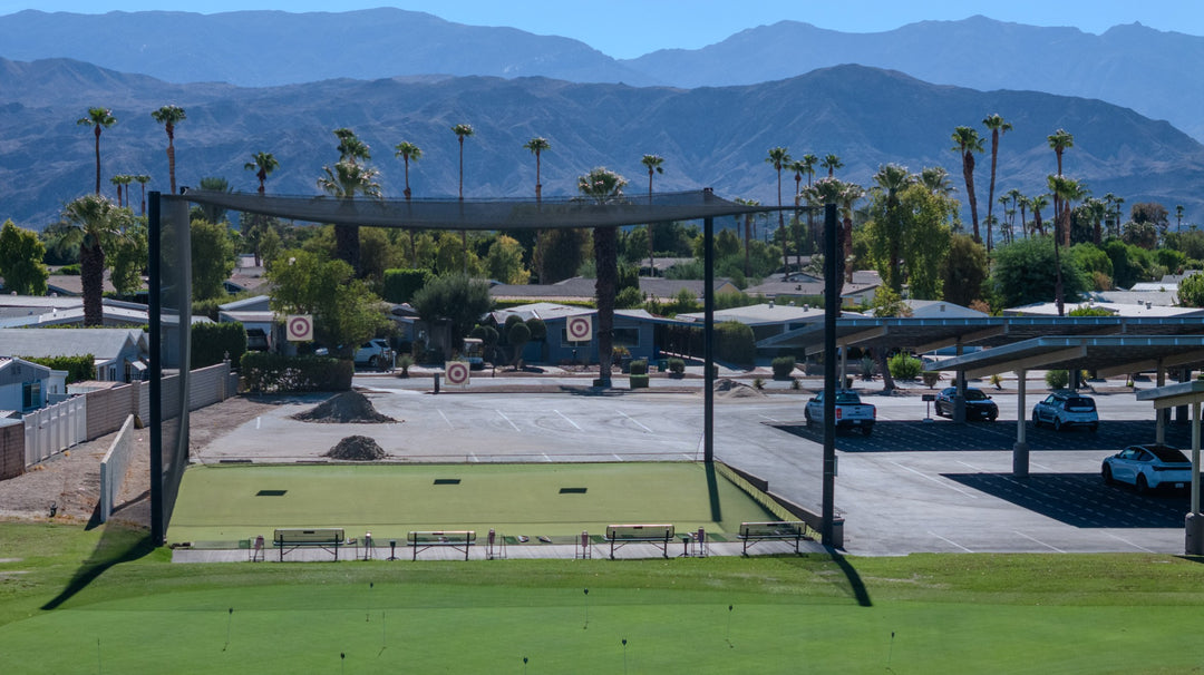 Outdoor bocce courts with shade structures, palm trees and mountains beyond