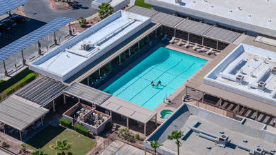 Aerial view of a turquoise swimming pool and shaded deck at Palm Desert Greens