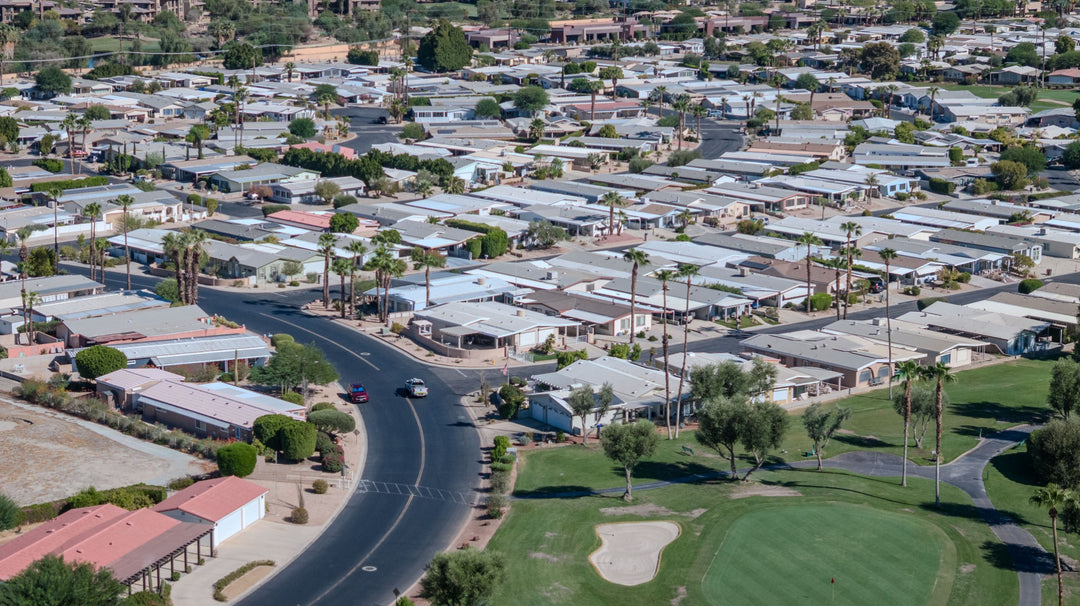 Curving Palm Desert Greens street beside a golf green and surrounding homes