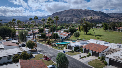Rancho Las Palmas homes and community pool beneath palms and mountains
