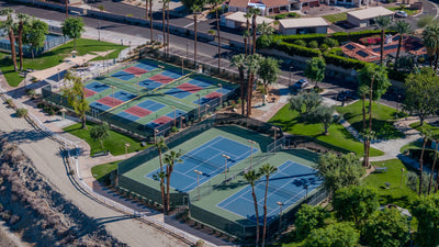 Aerial view of colorful pickleball courts and blue tennis courts at Rancho Mirage Community Park.