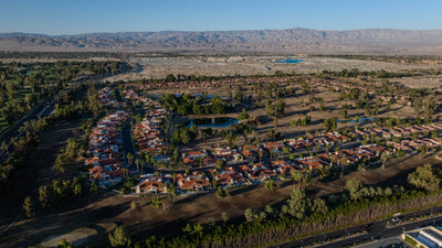 Aerial overview of Rancho Mirage Country Club homes and golf-course landscape, with mountains beyond.