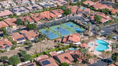 Rancho Village pool, spa, recreation building and courts surrounded by tile-roofed homes.