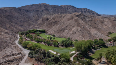 Golf green and landscaped grounds tucked beneath rocky Santa Rosa Mountain slopes at Sensei Porcupine Creek.