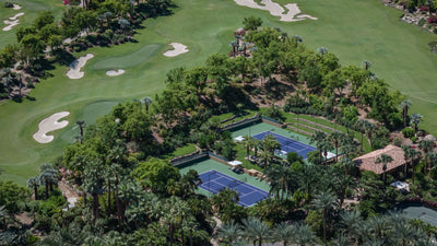 Tennis courts bordered by palms, gardens and golf fairways at Sensei Porcupine Creek.