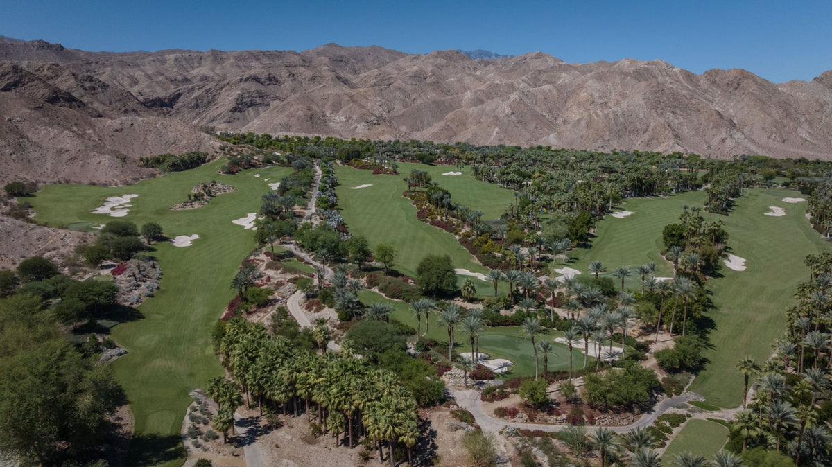 Elevated view of Sensei Porcupine Creek, with palm-lined grounds, golf fairways and the Santa Rosa Mountains in Rancho Mirage.