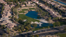 Aerial view of a suburban neighborhood with houses, roads, and a large pond in sun city shadow hills ca