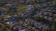 Aerial view of a suburban neighborhood with houses, roads, and greenery.