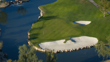 Golf course with green grass and sand bunkers near a body of water in scsh