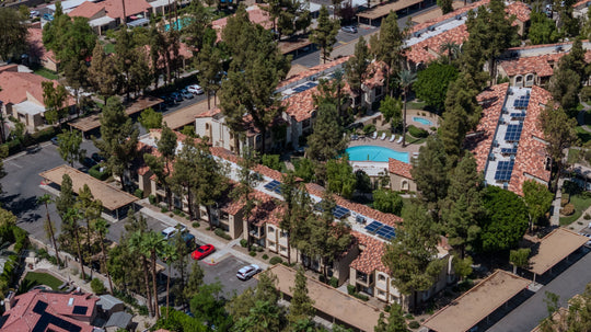 Aerial view of The Regent Palm Desert's tile-roofed apartment buildings, covered parking and pool courtyard. Photo by Mark Miller, September 10, 2026.
