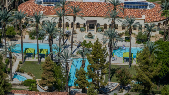 Main swimming pools, green cabanas and palm-lined clubhouse terrace at The Regent Palm Desert. Photo by Mark Miller, September 10, 2026.