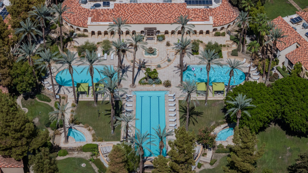 Aerial view of The Regent Palm Desert's main pool complex, lap pool, spas, palms and clubhouse. Photo by Mark Miller, September 10, 2026.