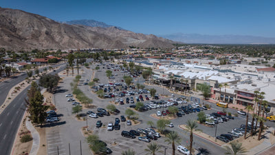 Aerial view of The Shops at Palm Desert, parking areas, and surrounding desert mountains.
