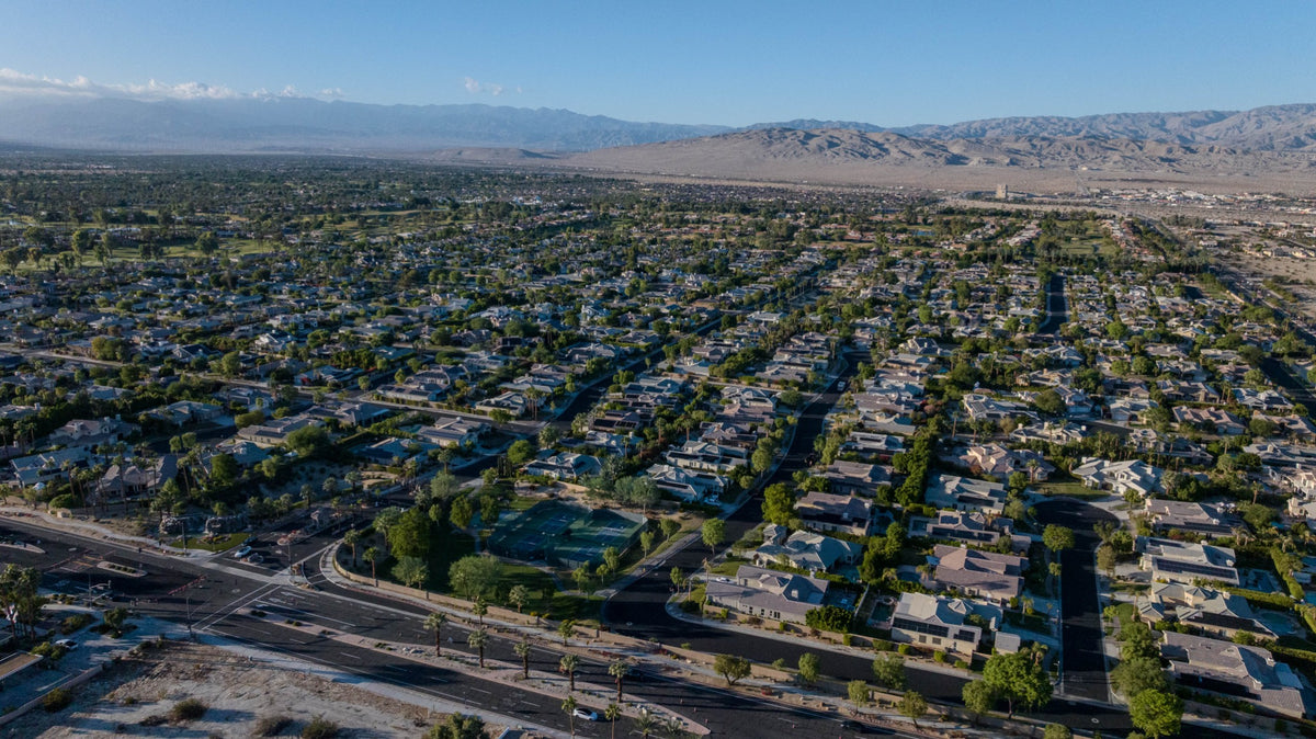 Aerial overview of Victoria Falls homes, landscaped streets and recreation courts in Rancho Mirage.