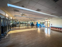 Large indoor space with wooden floor and mirrors on the wall at the Montecito Clubhouse in sun city shadow hills ca